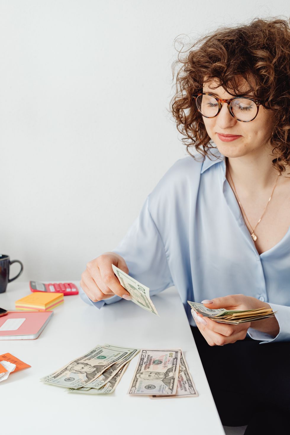 woman counting money on table, how to invest in stocks