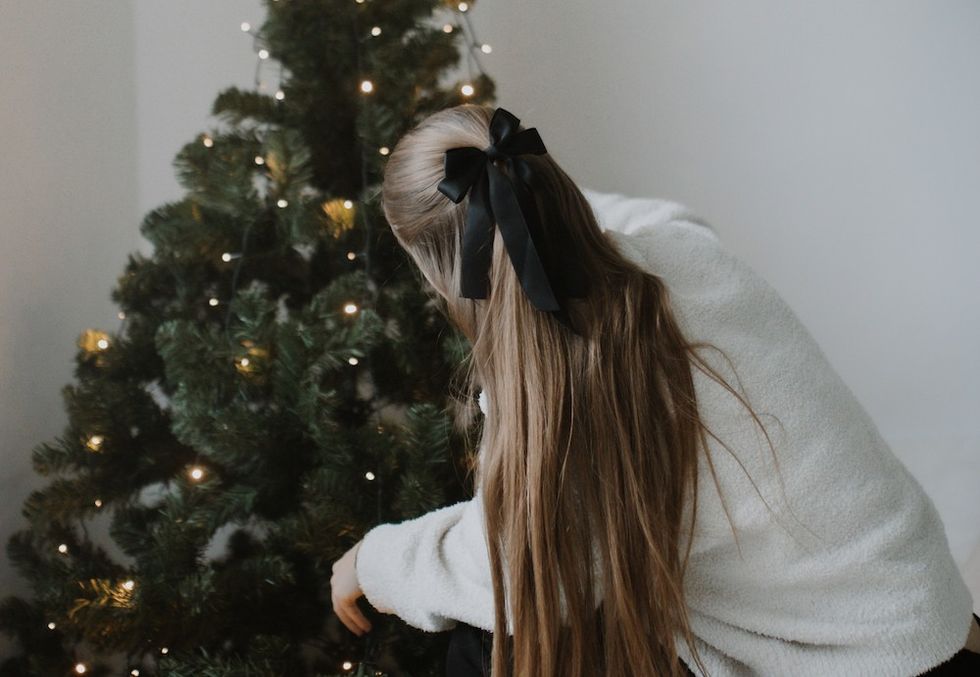 woman decorating a christmas tree