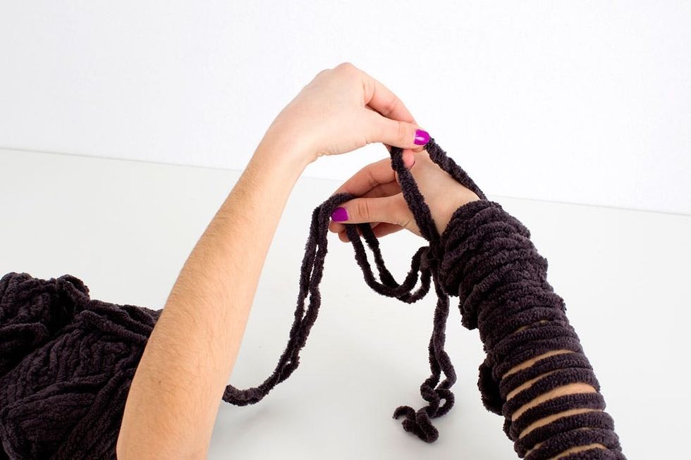 woman demonstrating how to knit a scarf