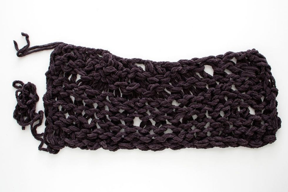 woman demonstrating how to knit a scarf