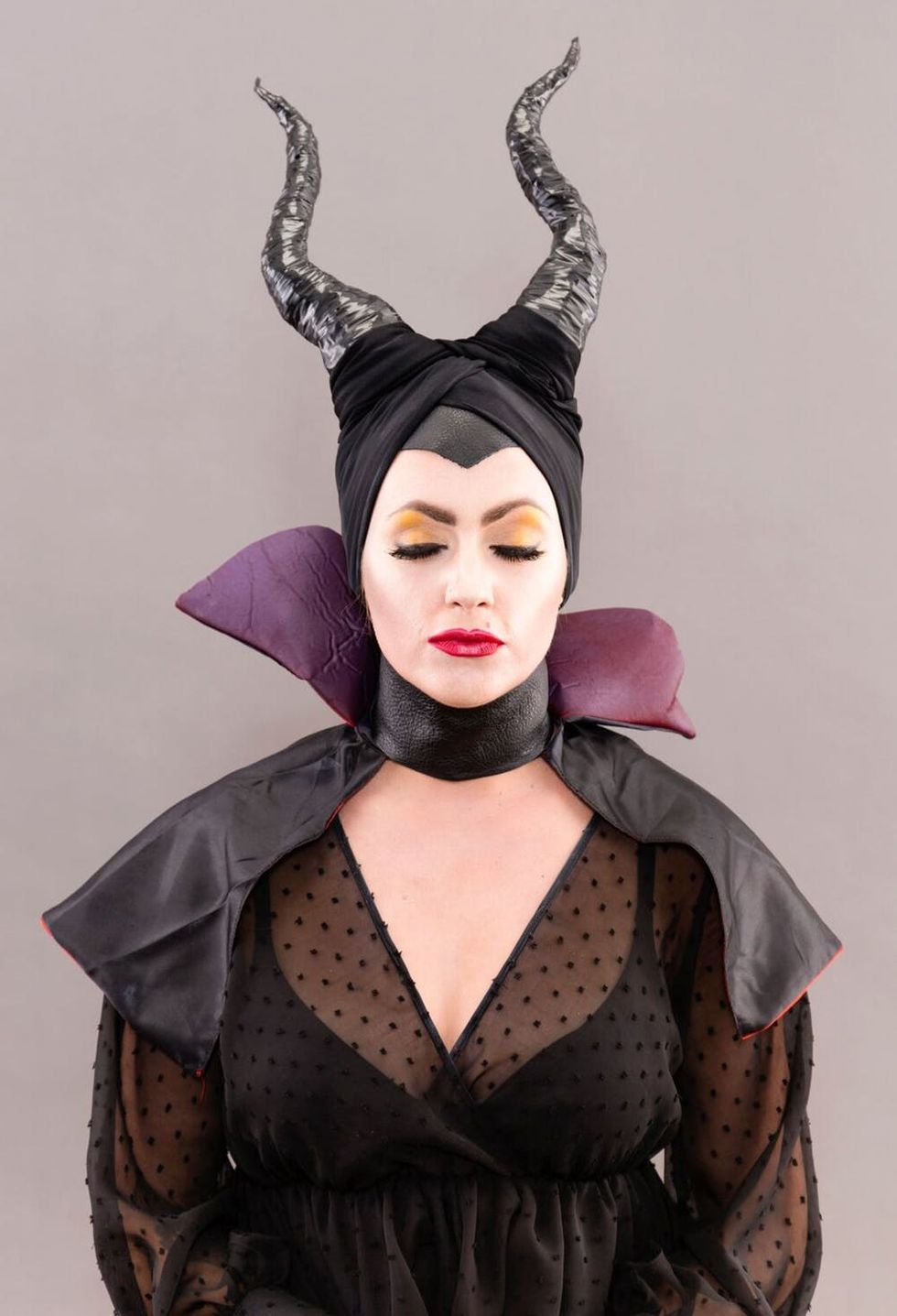 Woman dressed as maleficent with eyes closed.