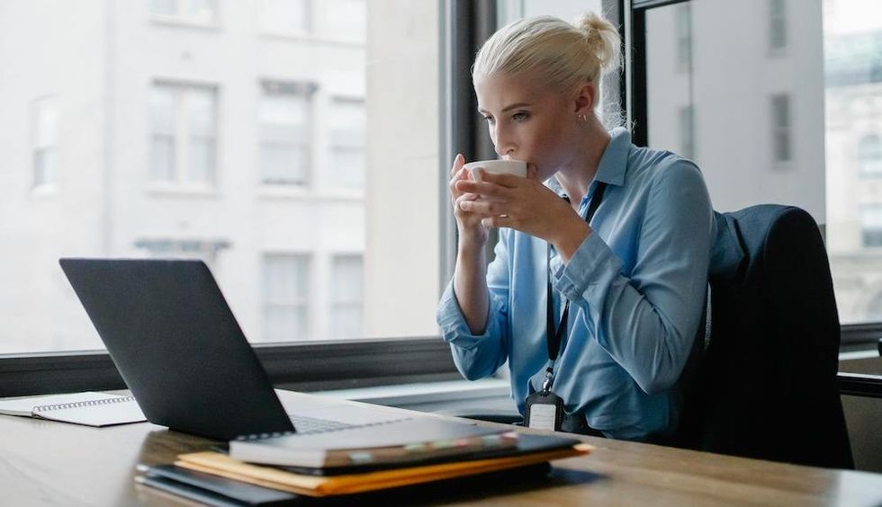 woman drinking coffee and checking her email