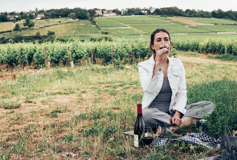 woman drinking wine at vineyard birthday trip ideas