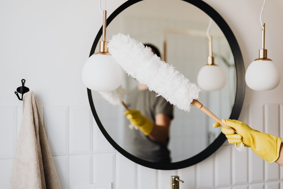 woman dusting bathroom mirror