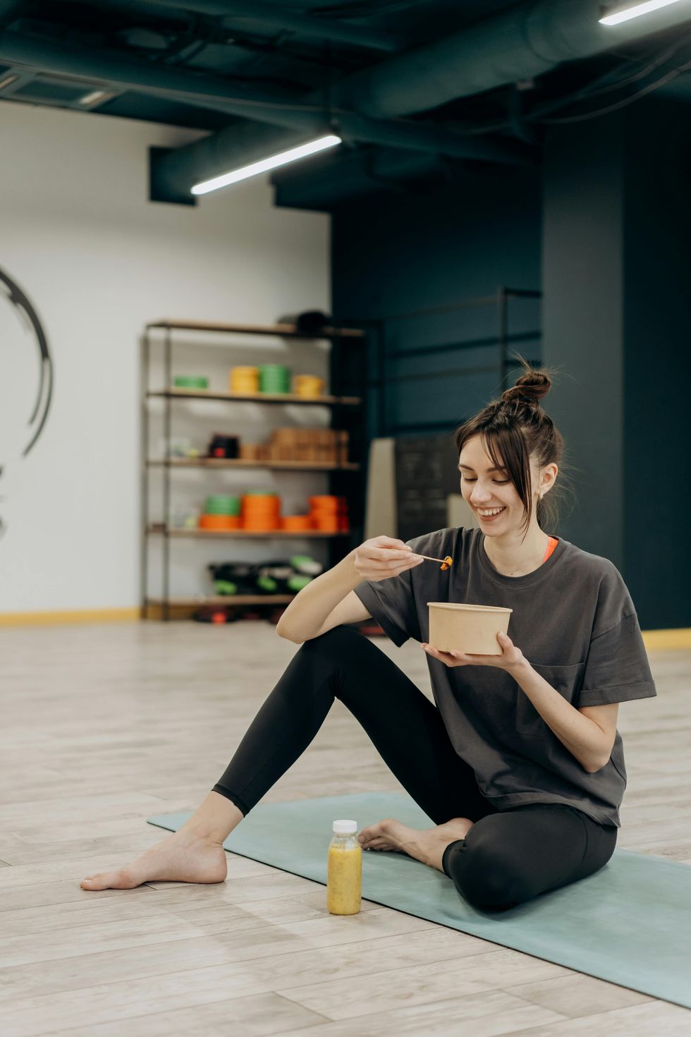 woman eating healthy bowl after yoga class