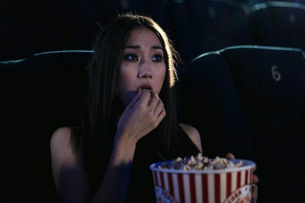 woman eating popcorn at the movies