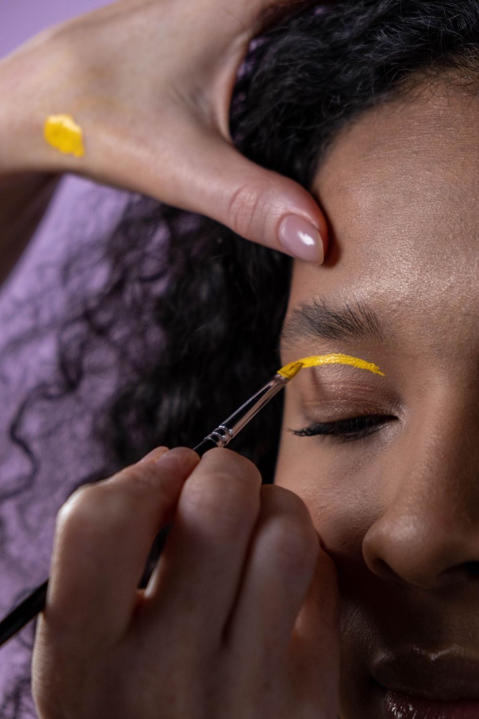 woman getting her eyelid painted yellow