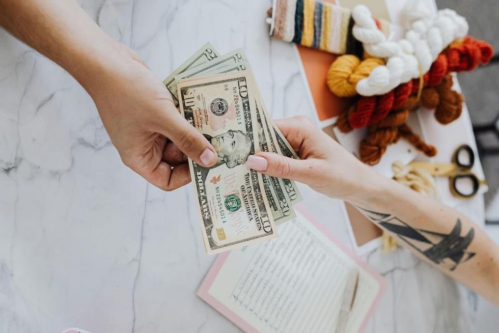 woman handing cash to another woman