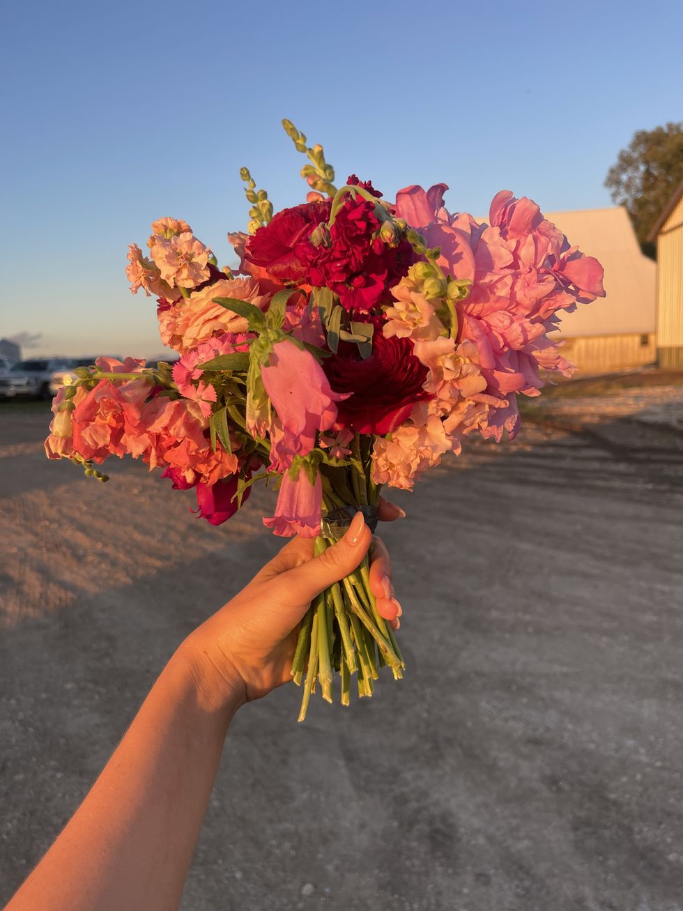 woman holding a bouquet of flowers at golden hour on the beach