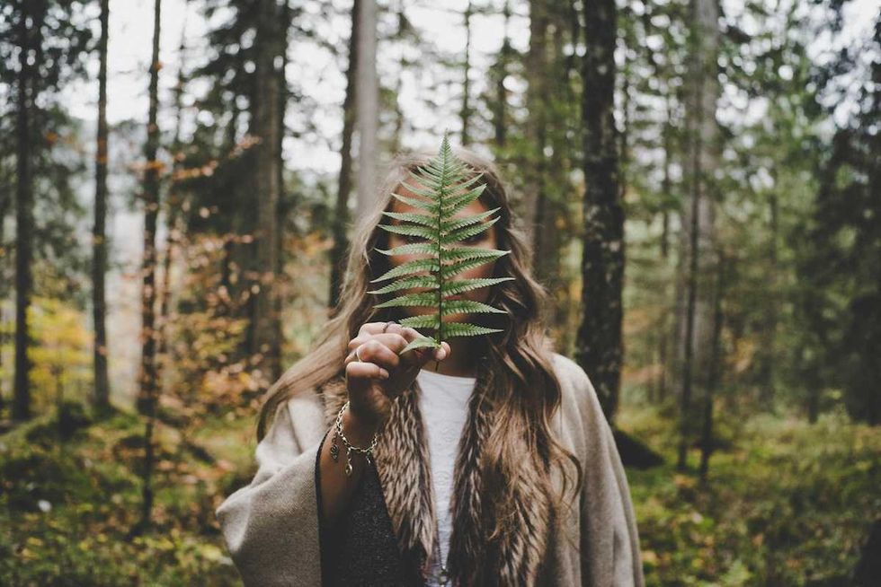 woman holding a leaf in the forest