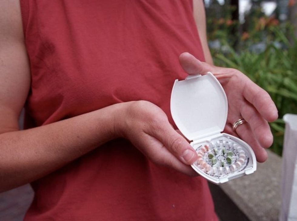 woman holding birth control pills