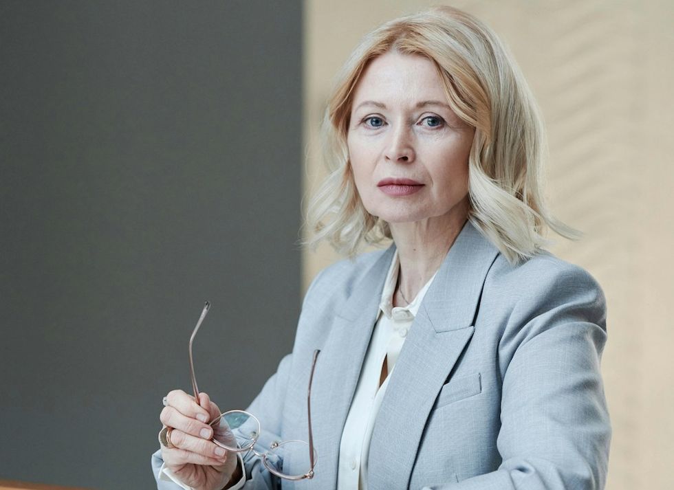woman holding her glasses at work