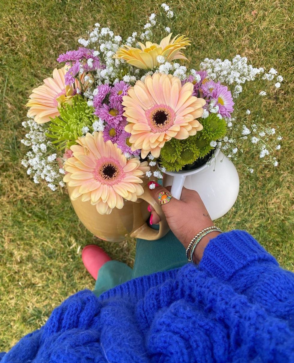 woman holding two vases full of flowers