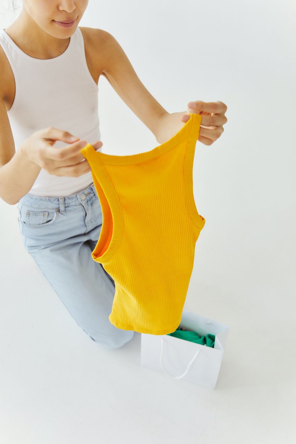 woman holding up yellow tank top color analysis