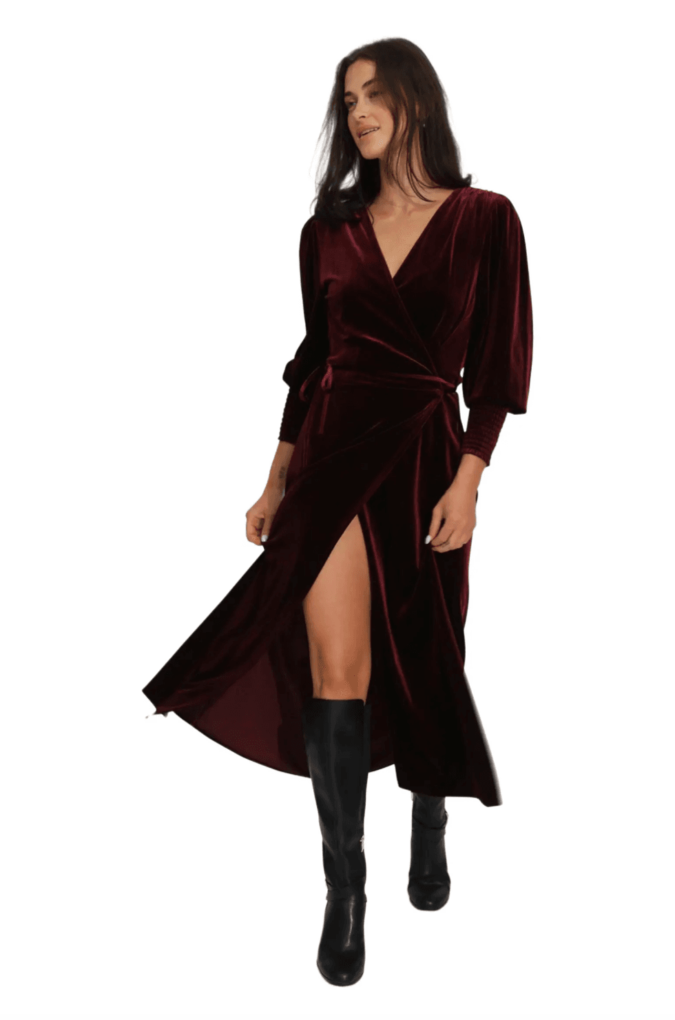 Woman in a burgundy velvet wrap dress and black knee-high boots.