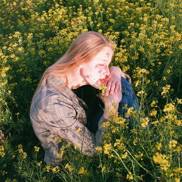 woman in a flower field with closed eyes