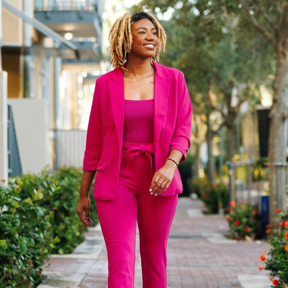 woman in a pink power suit walking down the street