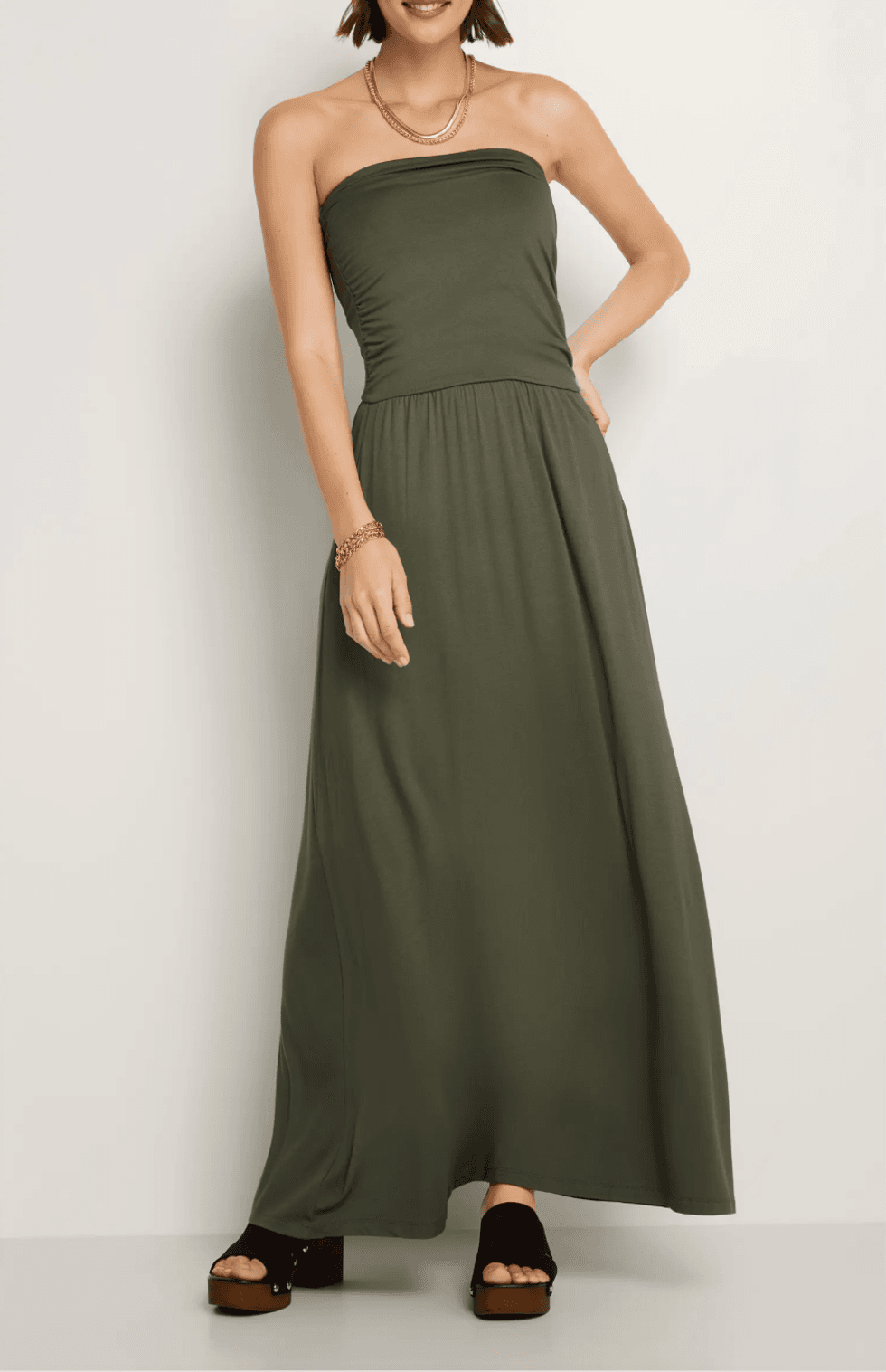 Woman in a strapless green maxi dress with black platform sandals.