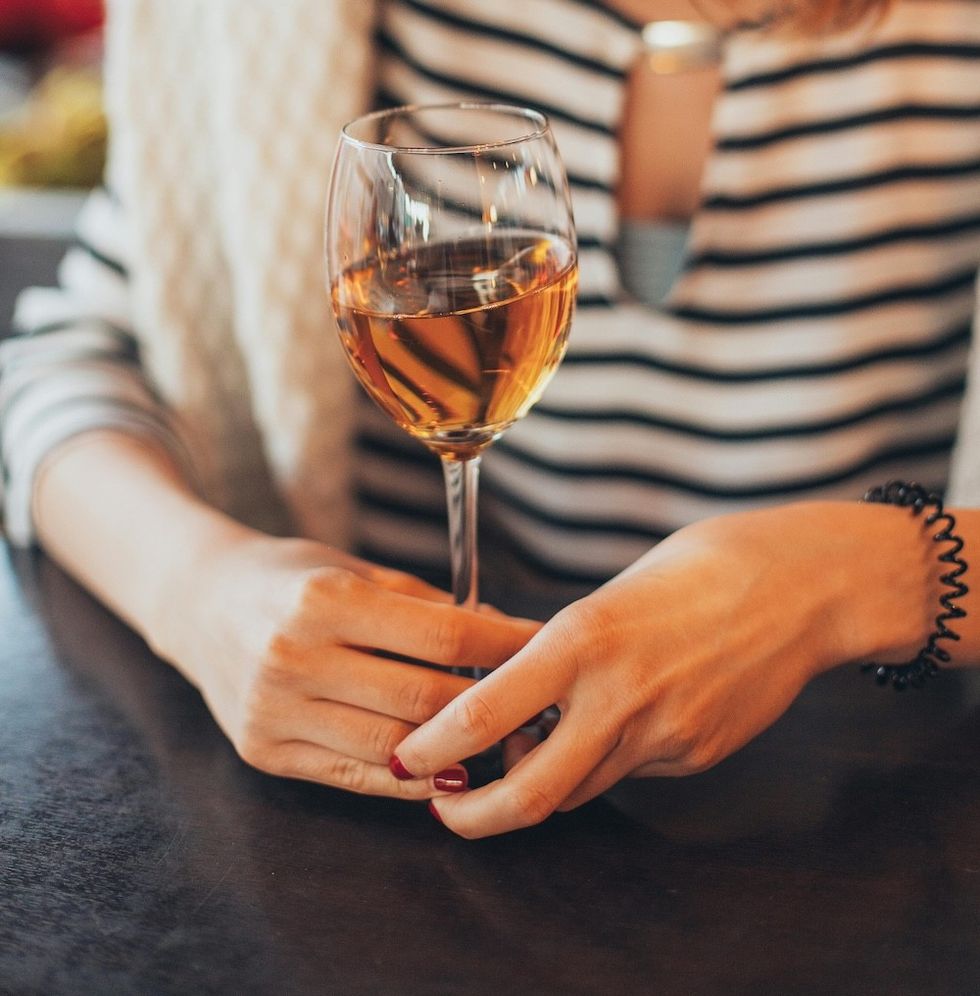 woman in a striped shirt holding a glass of wine