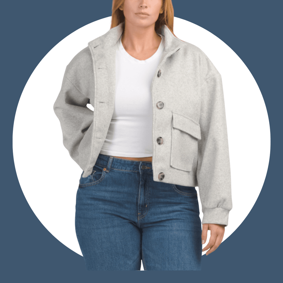 Woman in gray jacket and jeans against a circular background.
