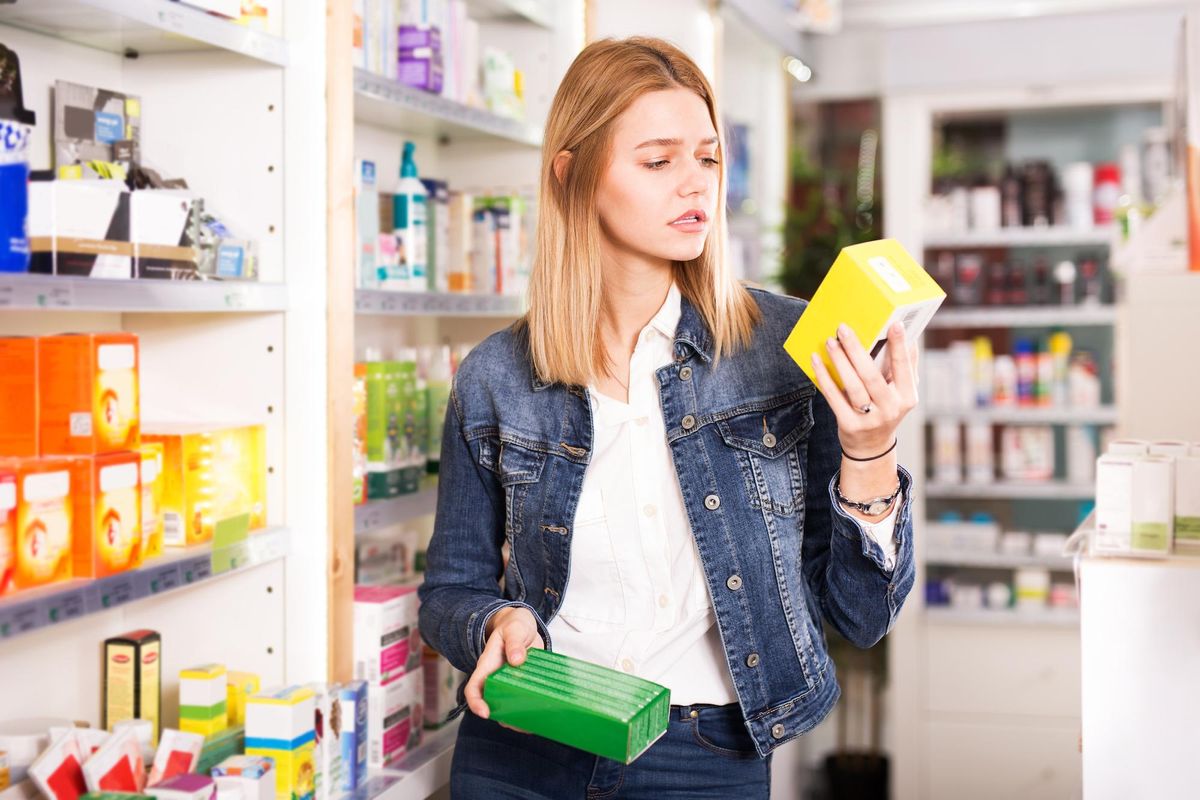 woman in pharmacy looking at wellness remedies