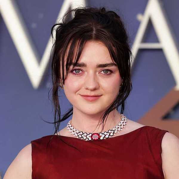 Woman in red dress with necklace, smiling at an event.