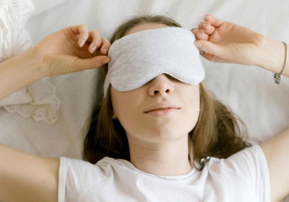 woman laying down with a sleep mask on
