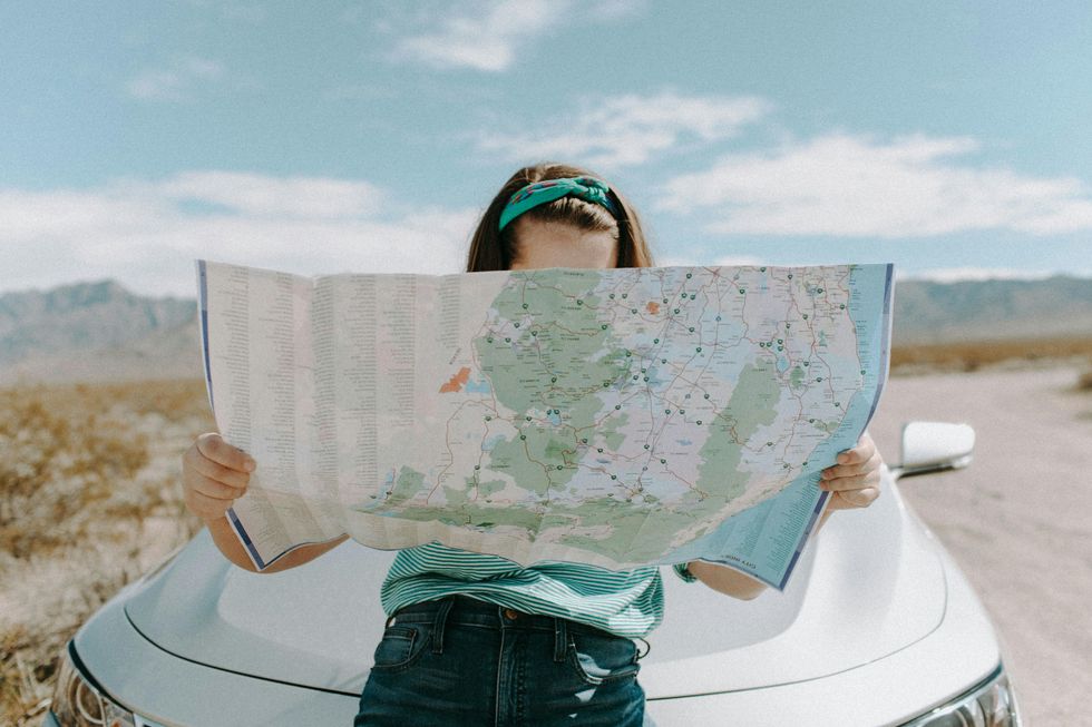 woman looking at a map birthday trip ideas