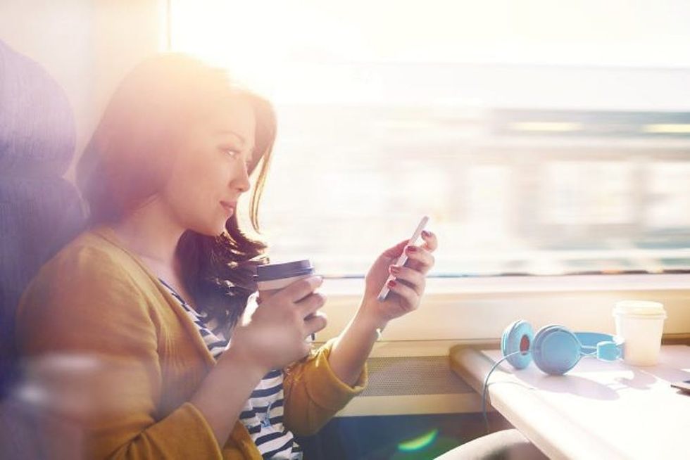 Woman on a commuter train looking at her phone.