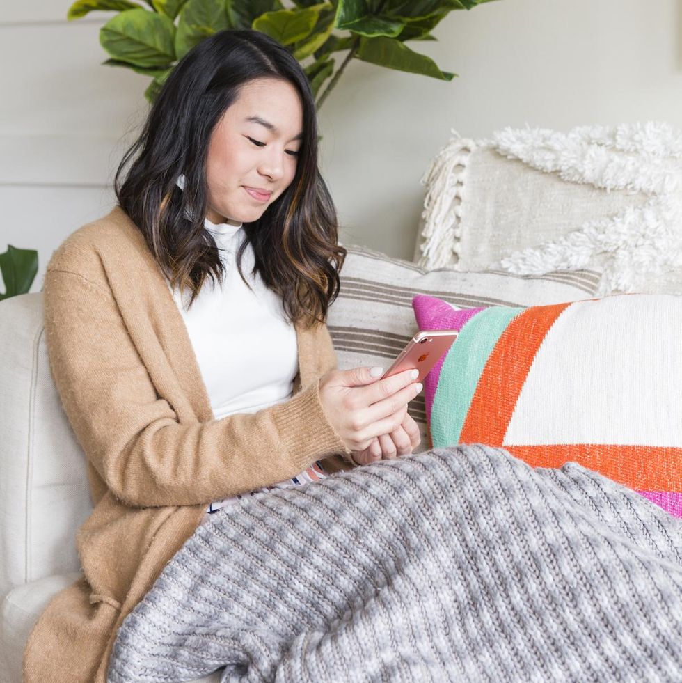 woman on her phone on the couch