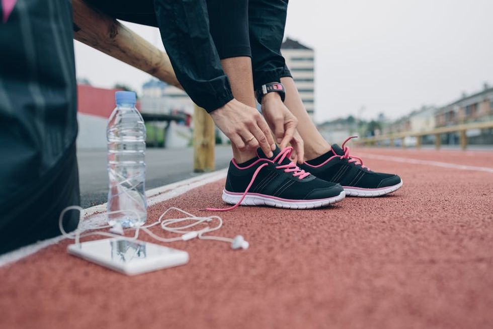 Woman on track tying running shoes