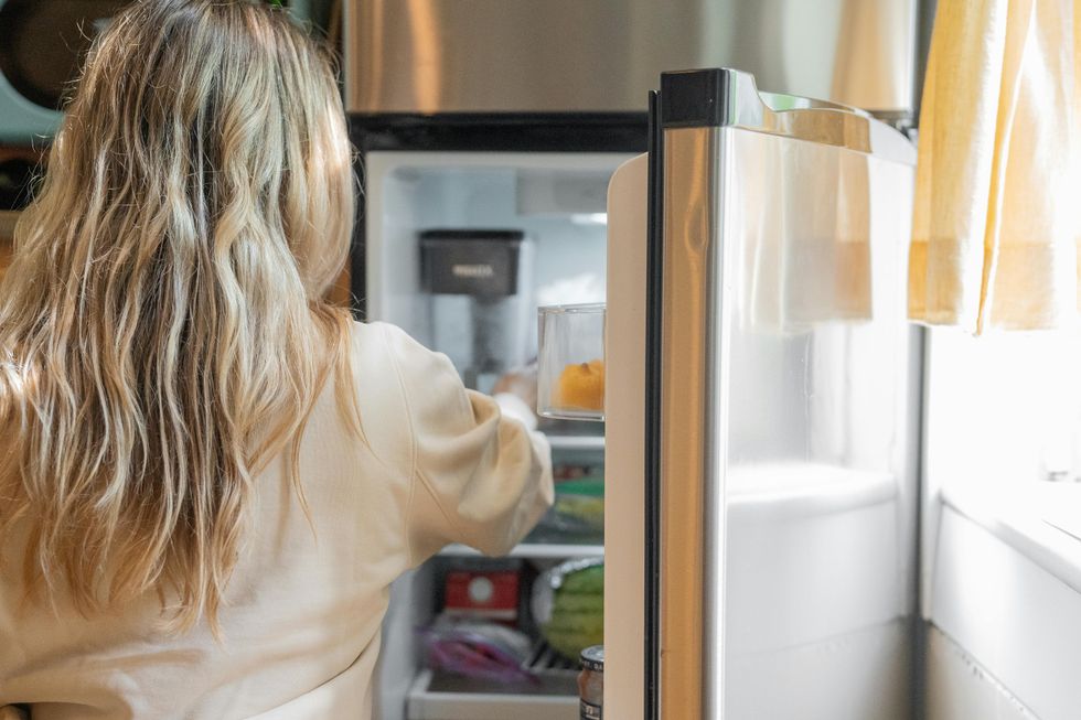 woman opening fridge