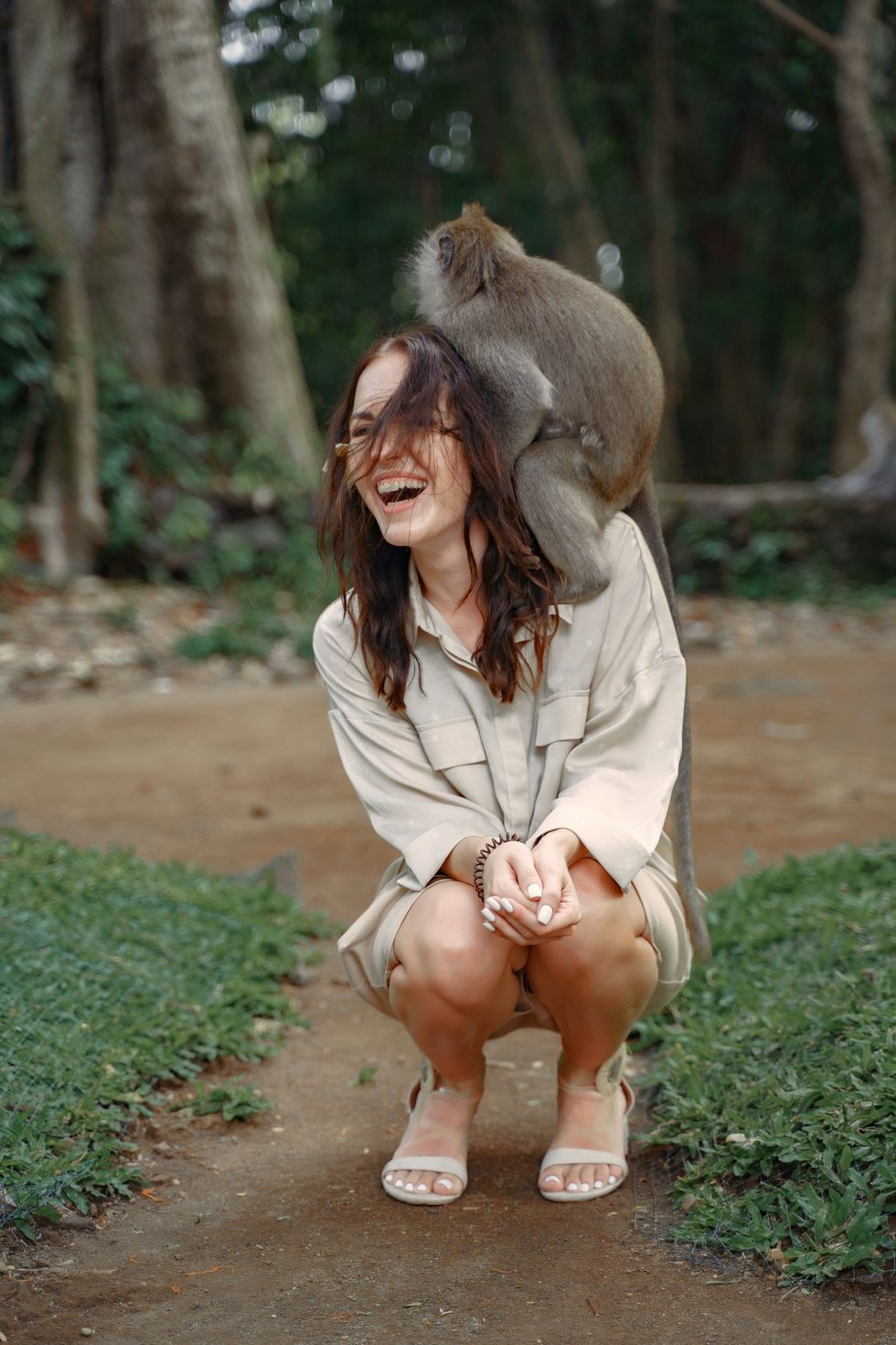 woman outside with monkey on shoulder
