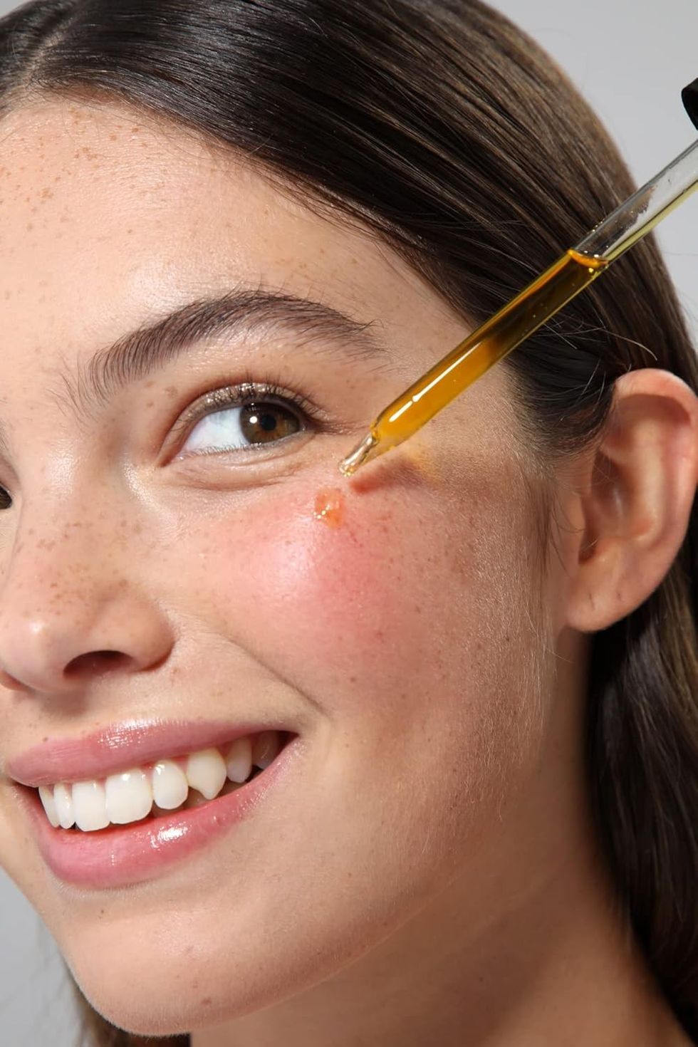 woman putting facial oils on her skin