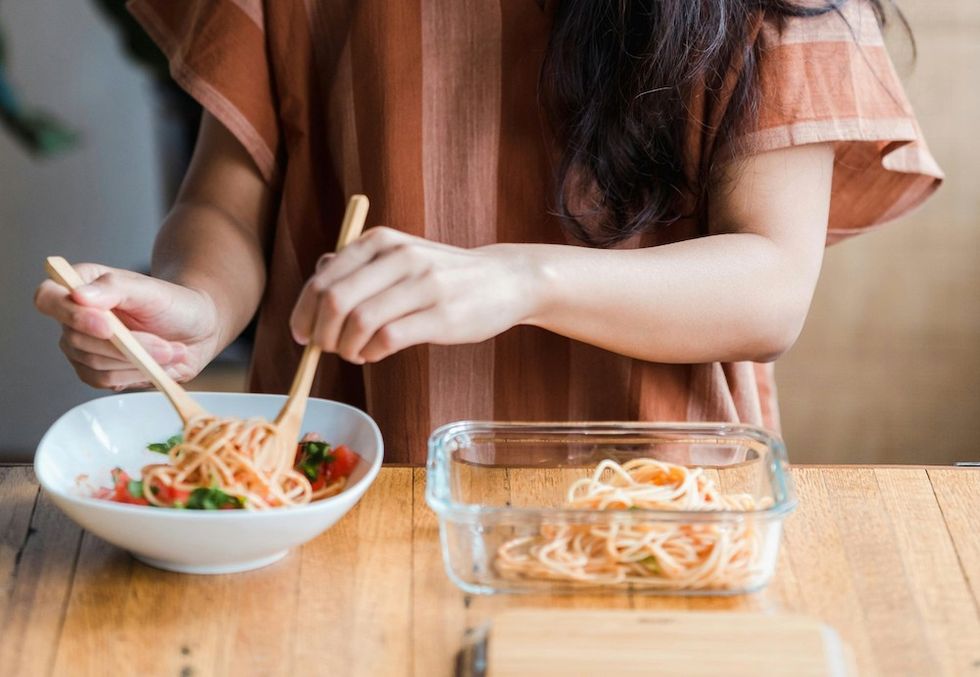 woman putting leftovers in a container