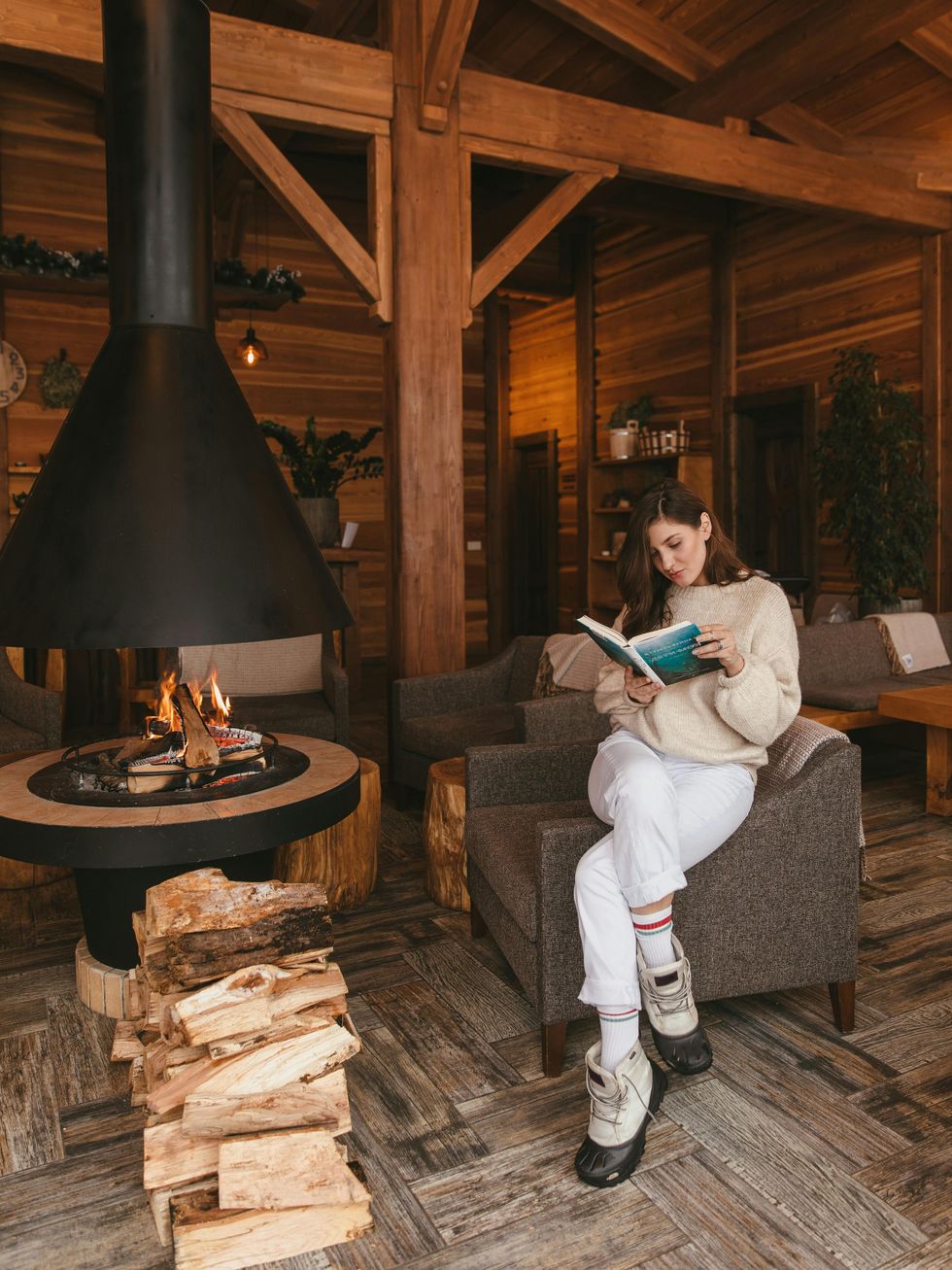 woman reading a book at log cabin birthday trip ideas