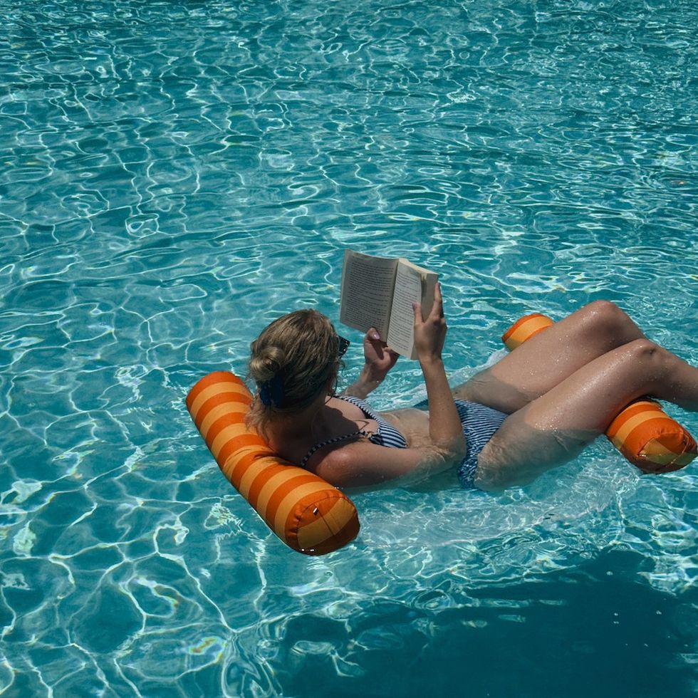 woman reading a book in the pool