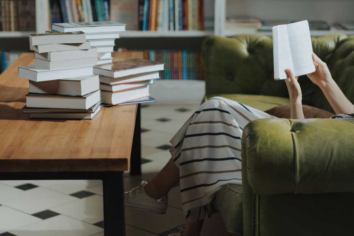 woman reading a book sitting on the couch