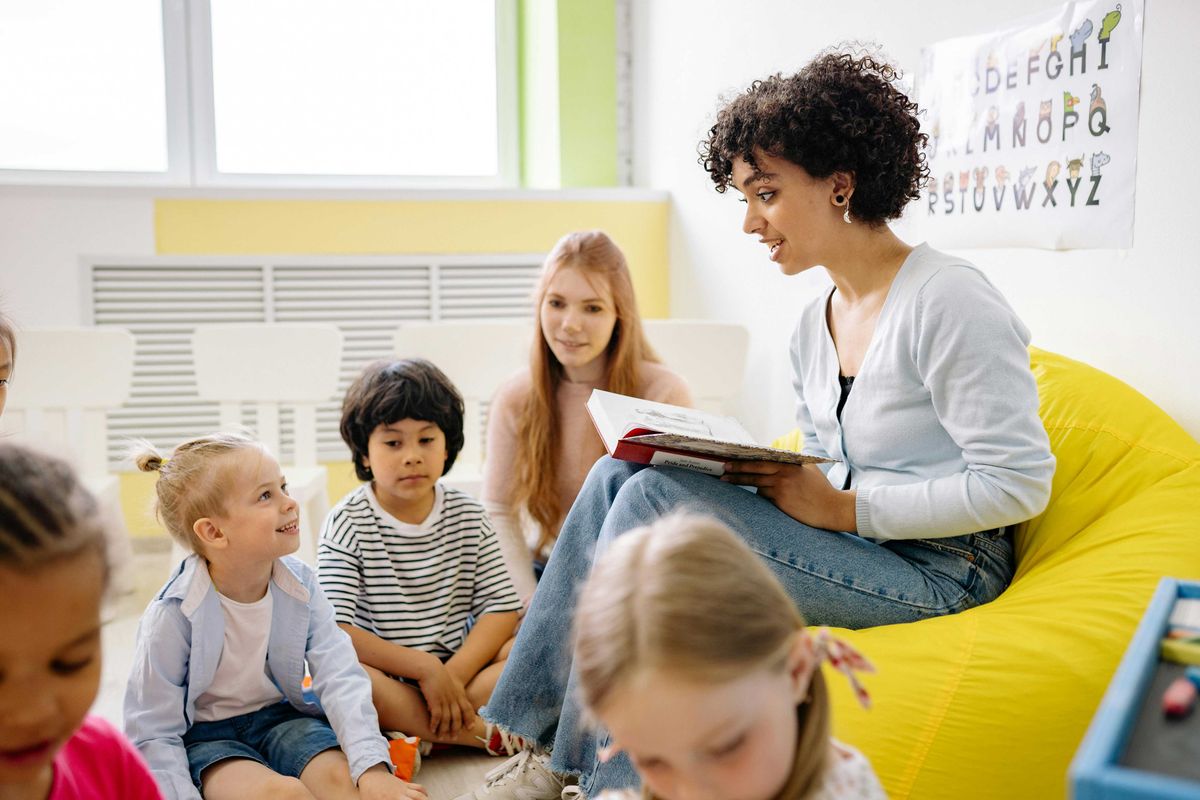 Woman reading to children in a classroom setting.