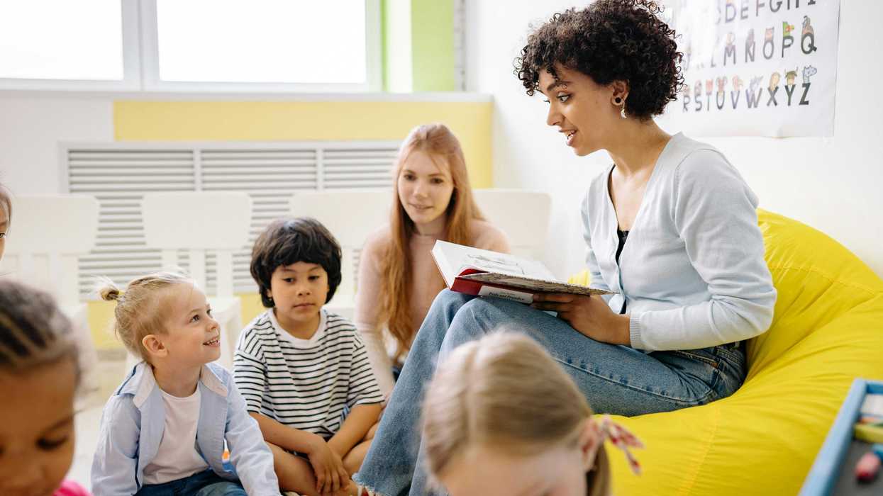Woman reading to children in a classroom setting.