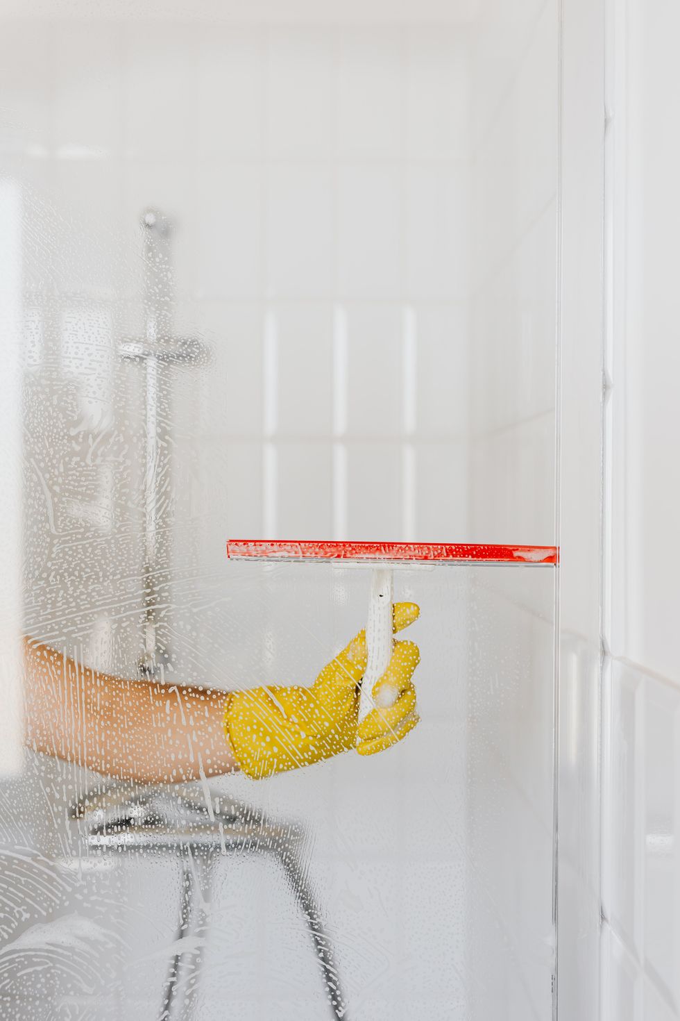 woman scrubbing glass shower door