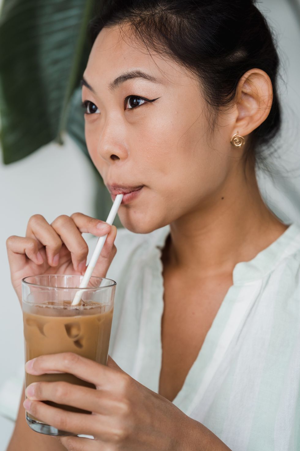 woman sipping iced coffee through straw