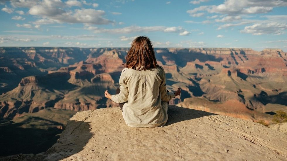 woman sitting on a mountain top