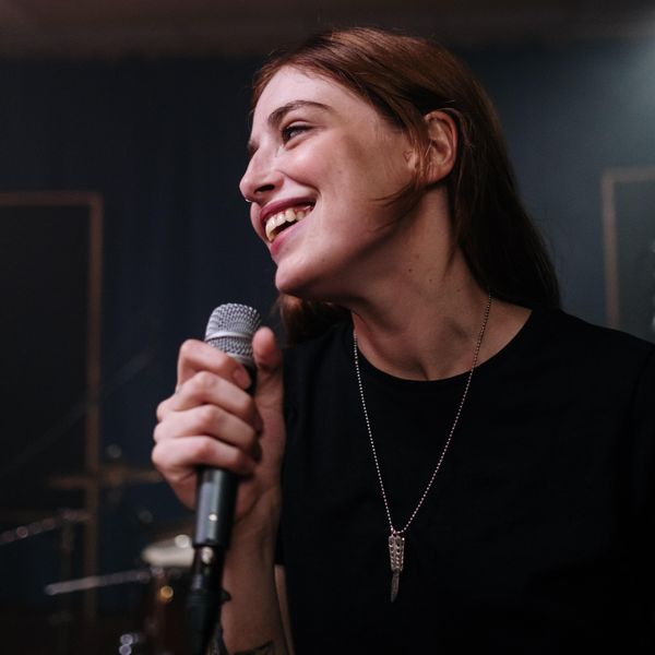 woman smiling while singing into a microphone date ideas
