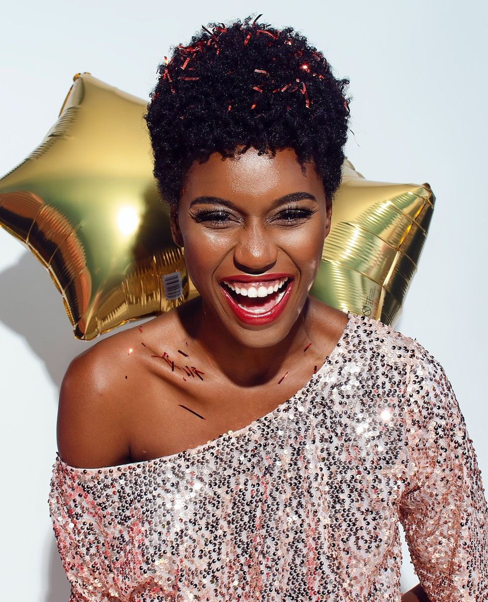 woman smiling with confetti on her collar bones