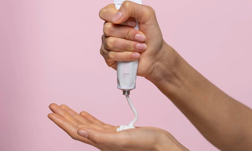 woman squeezing sunscreen into her hands