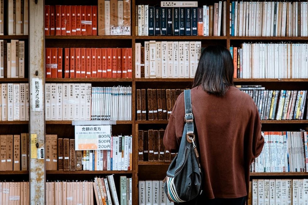 woman standing in front of a wall of books