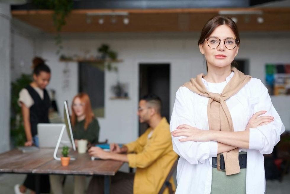 woman standing in front of her team at work