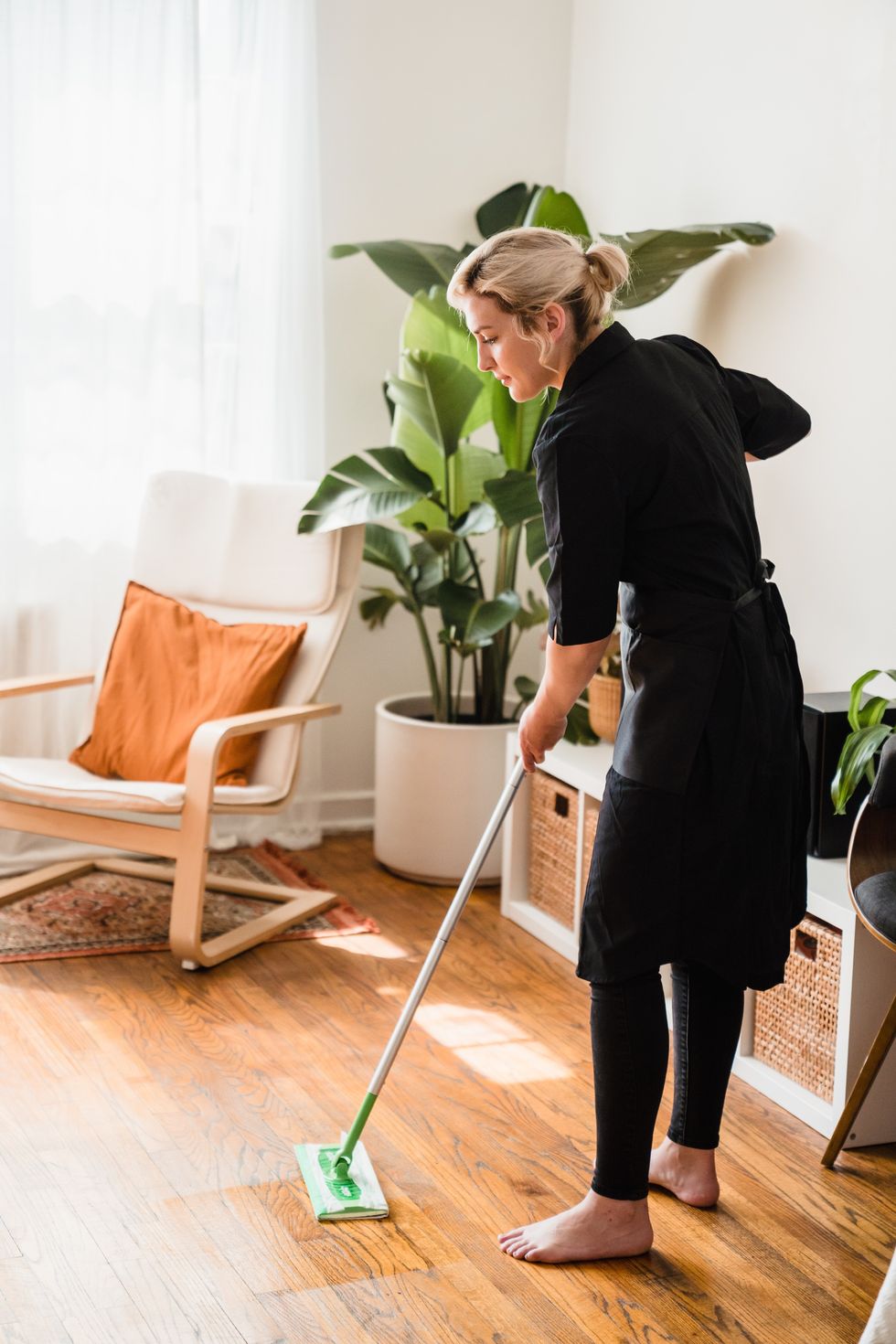 woman swiffering her floor for the sunday reset
