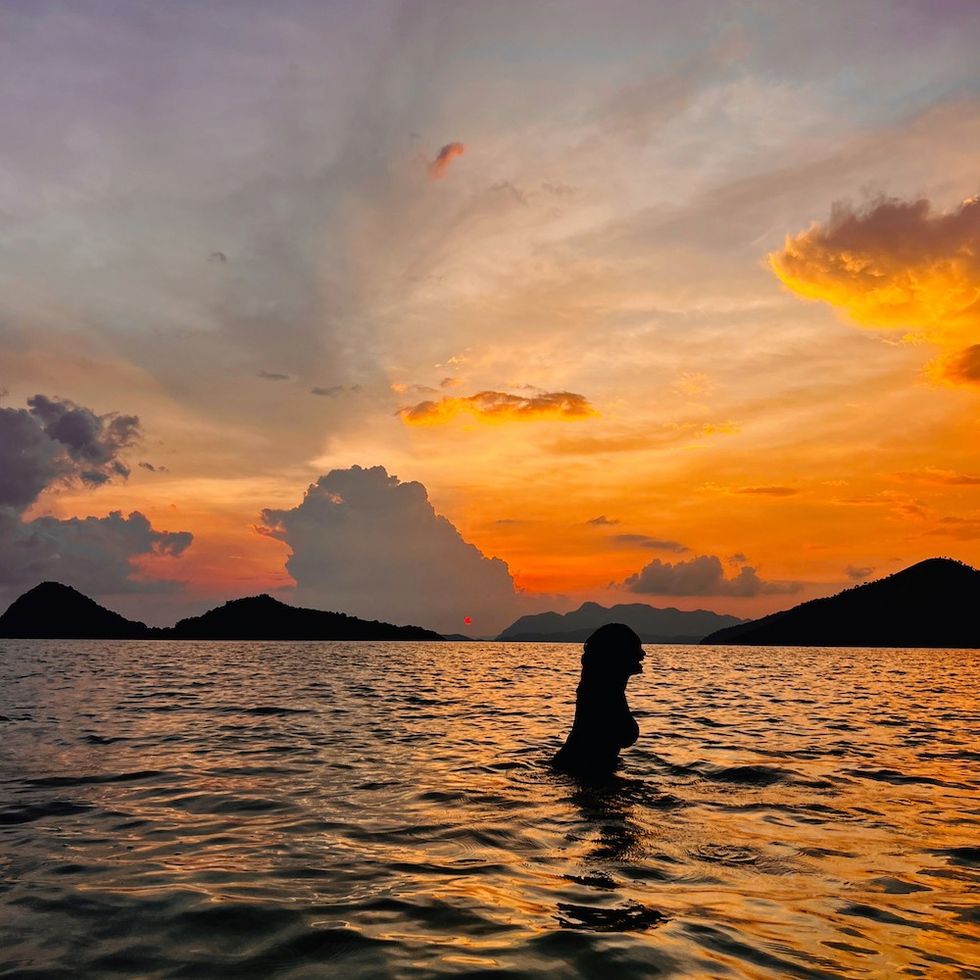 woman swimming at sunset